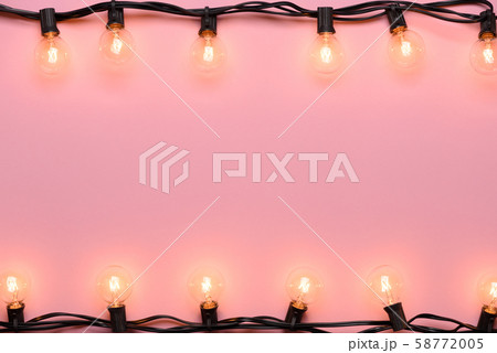 Light bulb string light. Retro garland edison warm lights on pink pastel background. 58772005