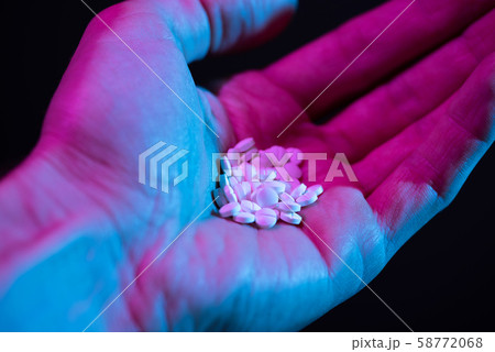 Pills pile in hand. Drug tablets in palm close-up on dark background Pills pile in hand. Drug tablets in palm close-up on dark background 58772068