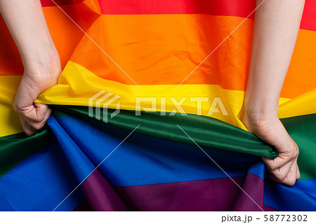 Woman hands pull rainbow Pride flag sign concept top view Woman hands pull rainbow Pride flag sign concept top view 58772302