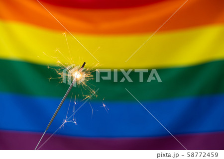 Sparkler and Gay pride LGBT flag. Sparkler and Gay pride LGBT flag. 58772459