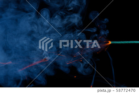 Firecracker firework fuse burning with smoke and sparkles on black background. Green dynamite fuse. 58772470