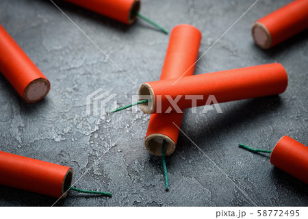 Red dynamite firecrackers with green cord fuse on table 58772495
