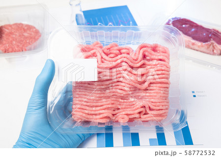 Plastic tray raw fresh ground meat in lab scientist hand. Laboratory meat quality analysis inspection check or cultured meat concept. Plastic tray raw fresh ground meat in lab scientist hand. Laboratory meat quality analysis inspection check or cultured meat concept. 58772532