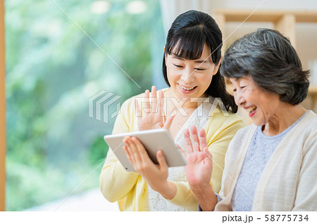 タブレット端末を操作する親子　母子　シニア女性　ミドル女性　2人 58775734