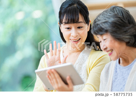 タブレット端末を操作する親子　母子　シニア女性　ミドル女性　2人 58775735