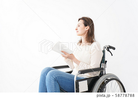 車椅子に乗り読書をする外国人の女性 58778788