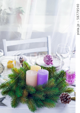 Place table setting for Christmas white table with purple decor elements and green wreath Christmas Place table setting for Christmas white table with purple decor elements and green wreath Christmas 58779540