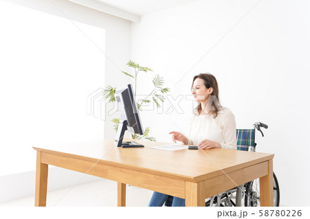 車椅子でデスクワークをする外国人の女性 58780226