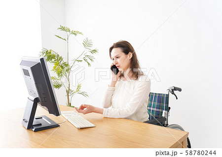車椅子でデスクワークをする外国人の女性 車椅子でデスクワークをする外国人の女性 58780244
