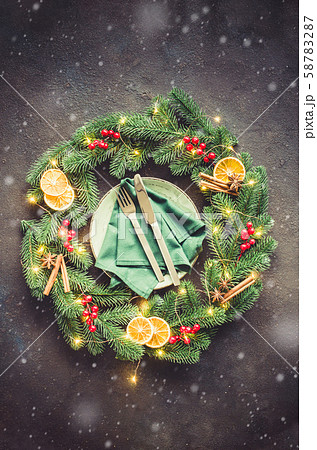 Festive table setting with xmas decorations in the form of a Christmas wreath. Festive table setting with xmas decorations in the form of a Christmas wreath. 58783287