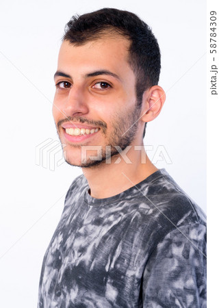 Closeup profile view of happy young bearded Persian man looking at camera 58784309