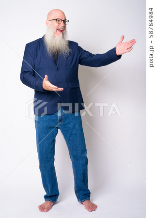 Full body shot of happy mature bearded bald businessman showing something 58784984