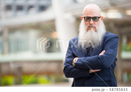 Mature bearded bald businessman with sunglasses in the city outdoors 58785633