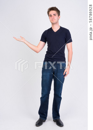 Full body shot of young handsome man showing something Full body shot of young handsome man showing something 58786928