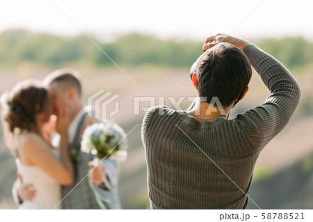 wedding photographer takes pictures of the bride and groom 58788521