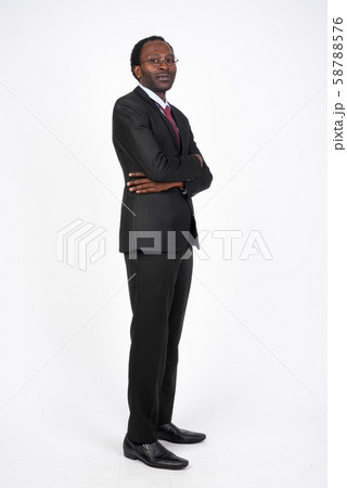Full body shot profile view of African businessman looking at camera Full body shot profile view of African businessman looking at camera 58788576
