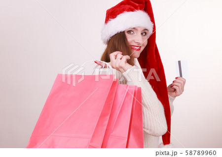 woman in Christmas hat holds credit card and 58789960