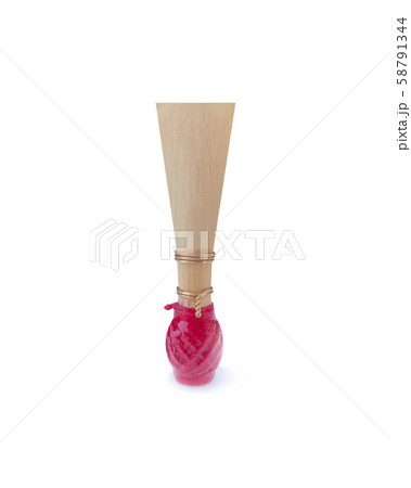 Double reed for bassoon with red thread on a white background. Tongue mouthpiece for wind musical instruments. With a slight shadow. Double reed for bassoon with red thread on a white background. Tongue mouthpiece for wind musical instruments. With a slight shadow. 58791344