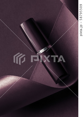 Luxury lipstick and silk ribbon on dark purple 58795509