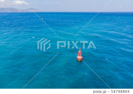 Floating red navigational buoy on blue sea, gulf. Drone 58798804