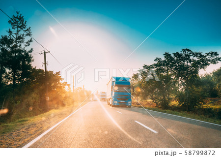 Truck In Motion On Country Road In Sunset Sun Sunshine Natural Sunlight. Tractor Unit, Prime Mover 58799872