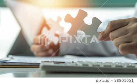 Business solution and strategy for corporate business success concept with jigsaw puzzle pieces in businessman hands finding problem solving idea and strategic planning 58801051