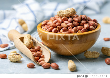 Organic peanuts in a wooden bowl. Organic peanuts in a wooden bowl. 58803324