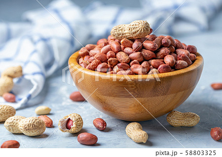 Raw peanuts in a wooden bowl. 58803325