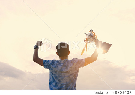 The young man holds the trophy after winning the The young man holds the trophy after winning the 58803402
