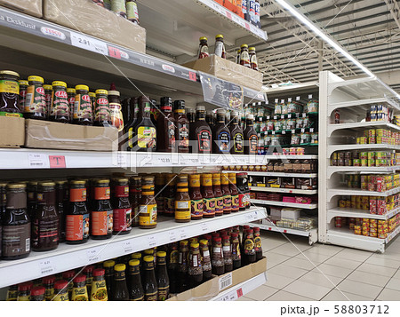 Selective focused variety of cooking sauce in the bottles displayed for sale in the supermarkets. Displayed on racks and separated by the brand to facilitate buyers. 58803712
