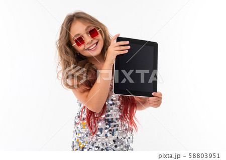 Teen girl with long blonde hair dyed with tips pink, in shiny light dress, black and white sneakers Teen girl with long blonde hair dyed with tips pink, in shiny light dress, black and white sneakers 58803951