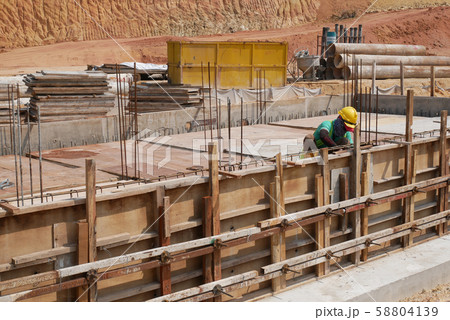Construction workers installing & fabricating ground beam timber form works at the construction site. The formworks made from timber and plywood.  58804139