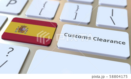 CUSTOMS CLEARANCE text and flag of Spain on the computer keyboard. Import or export related 58804175