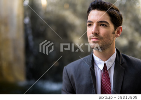 Portrait of young handsome businessman wearing suit in city Portrait of young handsome businessman wearing suit in city 58813809
