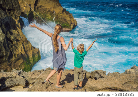 mother and son tourists against the background of the sea Angel's Billabong in Nusa Penida, Bali 58813835