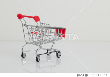 Miniature shopping cart and basket on white Miniature shopping cart and basket on white 58815873