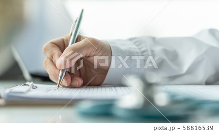 Medical doctor writing on patient personal health care record discharge form, or prescription paperwork in hospital office, clinic center for healthcare and life insurance concept 58816539