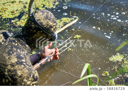 diver in wet suit loading harpoon shotgun for hunting fishing diver in wet suit loading harpoon shotgun for hunting fishing 58816729