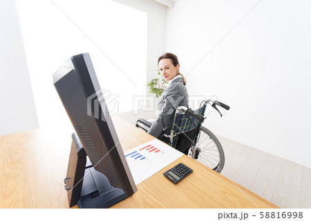 車椅子に乗って仕事をする外国人の女性 車椅子に乗って仕事をする外国人の女性 58816998