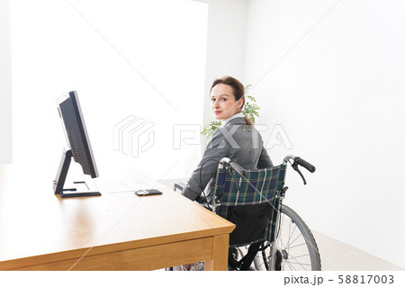 車椅子に乗って仕事をする外国人の女性 車椅子に乗って仕事をする外国人の女性 58817003