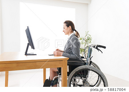 車椅子に乗って仕事をする外国人の女性 58817004