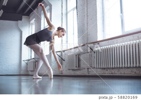 Young ballet dancer bend down in studio active lifestyle 58820169