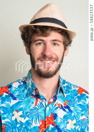 Face of happy young bearded tourist man with hat smiling 58823537