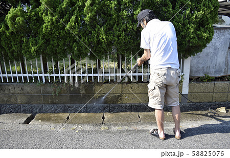 高圧洗浄機を使って塀を綺麗にする男性 高圧洗浄機を使って塀を綺麗にする男性 58825076