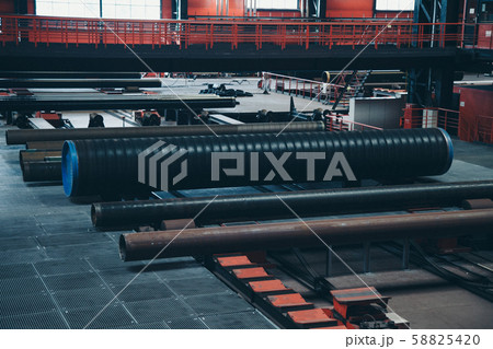 heavy industry concept, construction machinery - long metal pipes inside a large room. Building materials in the hangar heavy industry concept, construction machinery - long metal pipes inside a large room. Building materials in the hangar 58825420