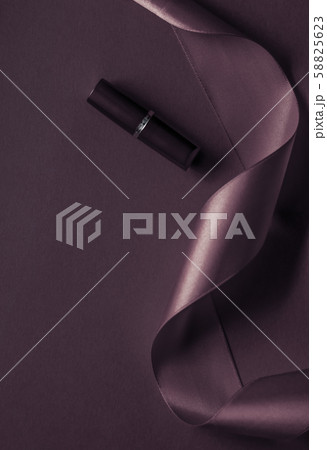 Luxury lipstick and silk ribbon on dark purple 58825623