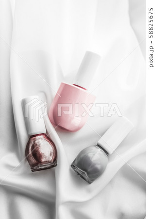 Nail polish bottles on silk background, french 58825675