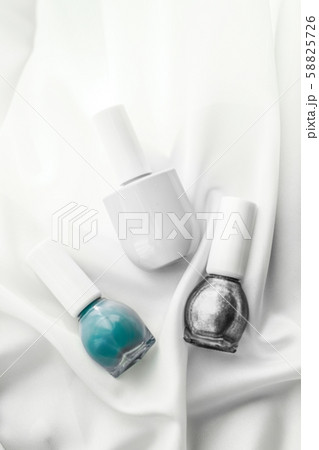 Nail polish bottles on silk background, french 58825726