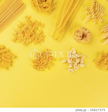 Italian pasta, shot from the top on a yellow background with copy space, a square flat lay banner 58827375