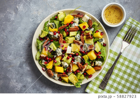 Arugula salad with mango, pomegranate, avocado, pecan nuts and blue cheese. 58827923